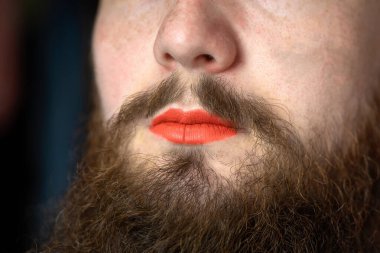 Dudaklarında kırmızı ruj lekesi olan sakallı adam yakışıklı transseksüel portresi lgbtq, transseksüel konsept yakın plan.