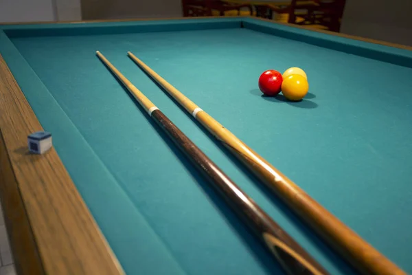 A green cloth billiards or pool table red,yellow and white ball,hobby and sport with copy space closeup