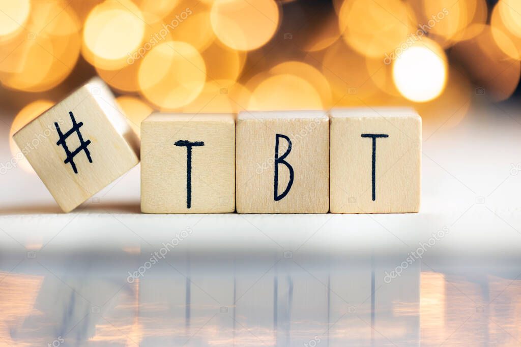 Hashtag TBT throwback Thursday written with wooden cubes with shiny bokeh background, social media concept colorful