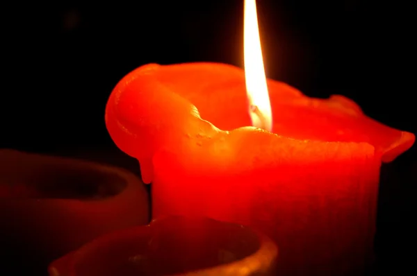 Оранжевая свеча в темноте — стоковое фото