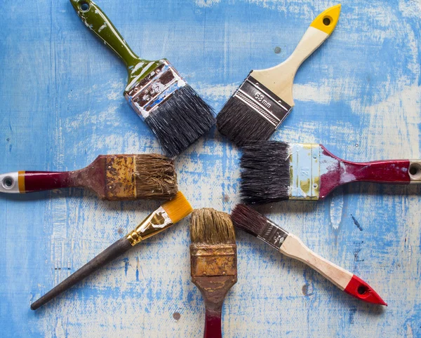 Eski ahşap mavi yüzeyindeki Boya fırçaları