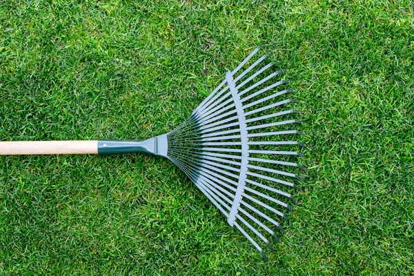 Hark op een houten stok, het verzamelen van gras knipsels, tuingereedschap — Stockfoto