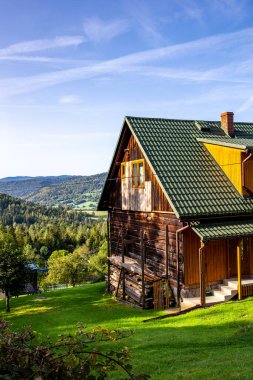 Polonya 'nın dağlık kesiminde geleneksel kahverengi ahşap ev Zywiec Beskid Dağları' ndaki bir köyün tepesinde, Milowka, Polonya.