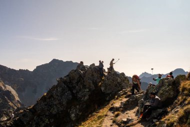 Tatra Dağları, Polonya, 21 / 09 / 2020. Turistler Polonya 'nın Tatra Dağları' ndaki Szpiglasowy Wierch Dağı 'nın kıyısında özçekim çubuklarıyla düşüncesizce selfie çekiyorlar..