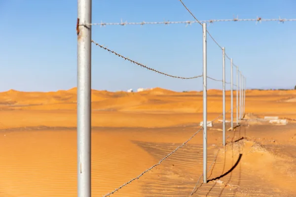 阿拉伯联合酋长国Al Madam鬼村的旧清真寺围栏中 有铁丝网围栏 背景为沙漠沙丘和蓝天 — 图库照片