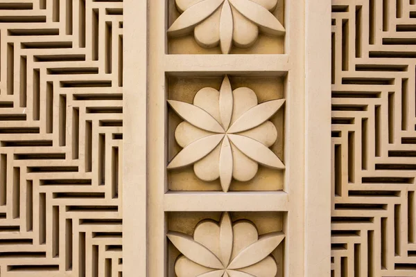 Arabic style carved stone openwork and relief, with floral patterns and geometric shapes and lines, on a building facade in Dubai JBR, UAE.