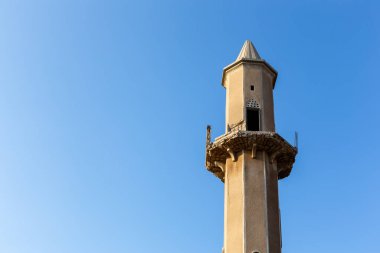 El Cezire El Hamra 'nın Arap Emirlikleri' nde kristal mavi gökyüzü arka planına karşı yıkılan bir caminin kumtaşı minaresi..