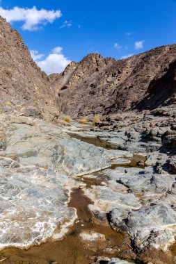 Wadi Shawka, Hajar Dağları, Birleşik Arap Emirlikleri, kayalık vadideki taşlı, neredeyse kurumuş nehir yatağındaki dağ patikalarını havuz ediyor..