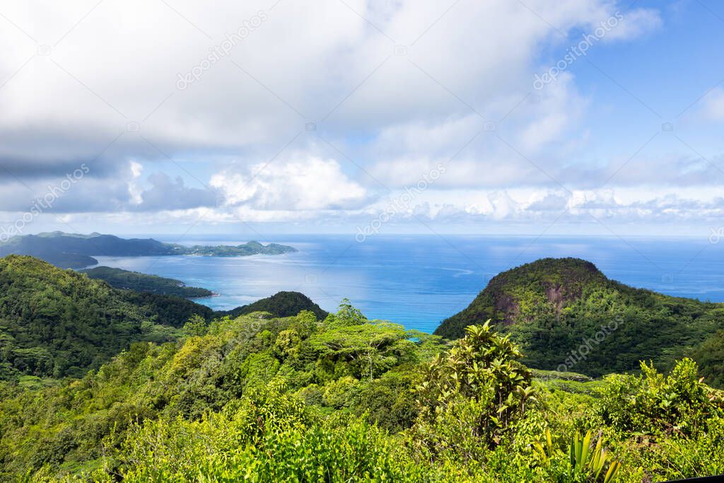 Landscape of Mahe Island coast seen from Venn's Town - Mission Lodge wooden viewing platform, lush tropical forest with crystal blue Indian Ocean.