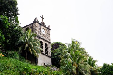 Lekesiz Gebelik Katedrali 'nin yanındaki tepede bulunan Taş Saat Kulesi (Tour de l' Horloge), saati ve Kutsal Haçı olan eski bina, Victoria, Mahe Adası, Seyşeller.