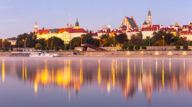 Polonya 'nın sakin Vistula Nehri' ndeki yansımalarıyla gündoğumu sırasında, Kraliyet Kalesi, Katedral ve Ortaçağ binalarıyla Varşova Eski Kent manzarasını aydınlattı..