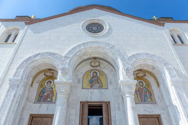 Belgrad, Sırbistan, 13.06.22. Aziz Sava Kilisesi beyaz mermer cephe, sütunlar ve Aziz Sava, İsa ve Aziz Simeon 'un altın mozaiği ile alçak açılı görüşü.