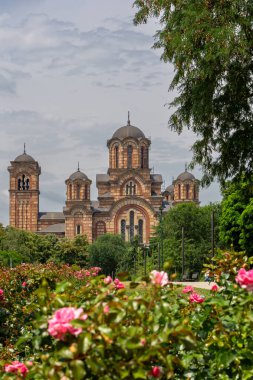 Yeşil yaz aylarında Sırbistan 'ın Belgrad kentinde yer alan bir Sırp Ortodoks kilisesi olan St. Mark Kilisesi, çiçek açan güller ve çevresindeki yeşil bitki örtüsüyle binayı görüyor..