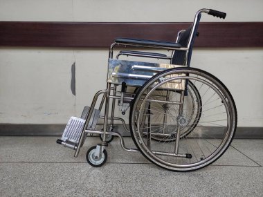 Tekerlekli sandalye eski bir duvarla koridorda duruyor..