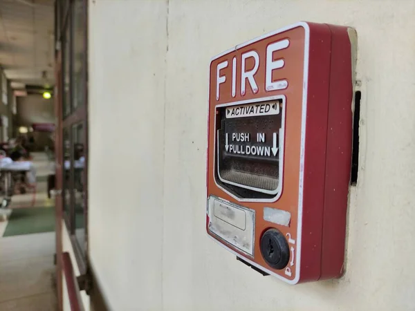 Fire alarm signal with English instructions on how to use it.  Installed on the sidewalk