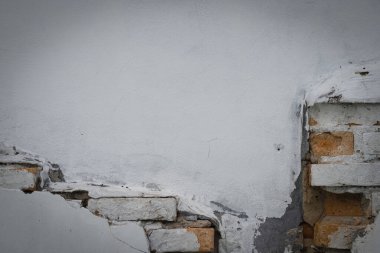 Tuğlaları görene kadar çürümüş eski beyaz beton duvar..