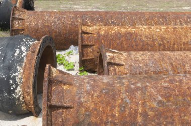 Kumsalda paslı bir petrol boru hattı.