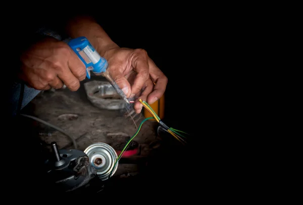 The mechanic's hand is repairing the electric motor. And there is a black space