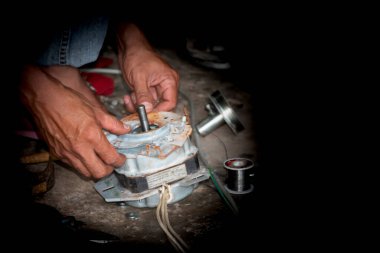 Tamircinin eli elektrikli motoru tamir ediyor. Ve siyah bir boşluk var.