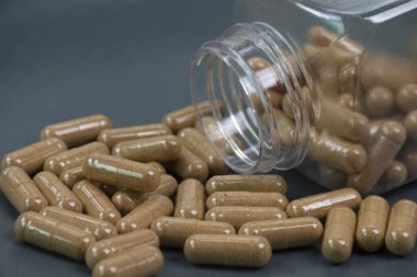 Plastik şişelerde bitkisel ilaç kapsülleri.