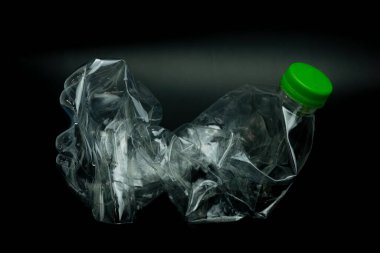 Siyah arka planda izole edilmiş bükülmüş plastik şişe