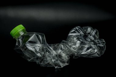 Siyah arka planda izole edilmiş bükülmüş plastik şişe