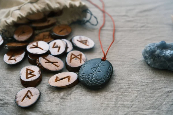 Runas de madeira em um saco de lona com um runescript de pedra — Fotografia de Stock