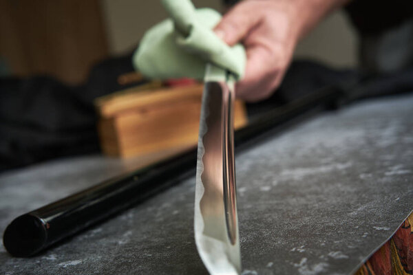 Man cleans blade of traditional Japanese katana sword
