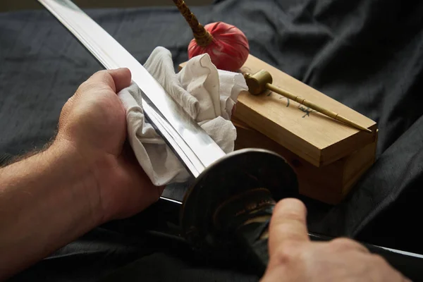 L'homme nettoie la lame de l'épée traditionnelle japonaise katana — Photo