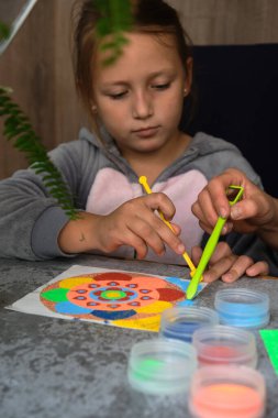 Renkli kumdan yapılmış bir mandala, kızların annesi.