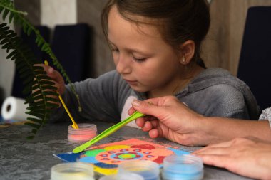 Renkli kumdan yapılmış bir mandala, kızların annesi.