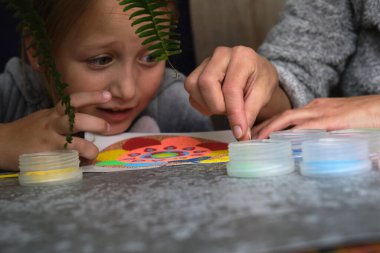 Renkli kumdan yapılmış bir mandala, kızların annesi.