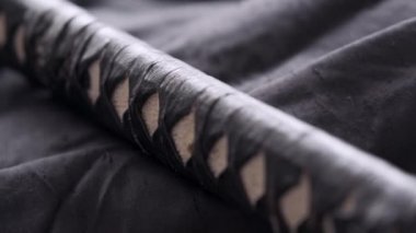 Bir adam katana kılıcını temizler.