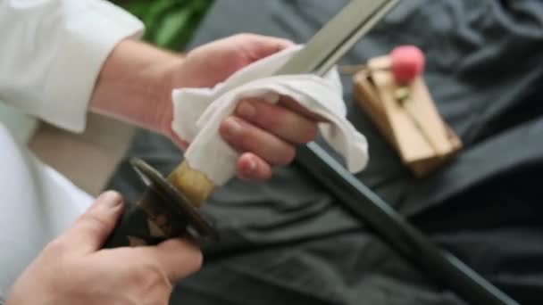Чоловік очищає свій меч катани — стокове відео