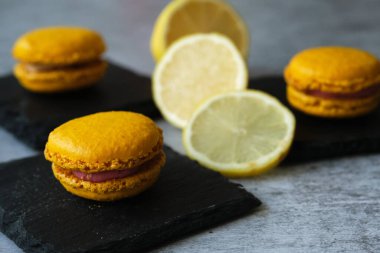 Sarı limonlu makarna kurabiyeleri gri arka planda.