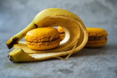 Sarı limonlu, muzlu, gri arka planda makarna kurabiyeleri.