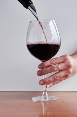 Kırmızı şarap bardağa dökülür.
