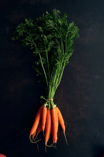 Siyah arka planda temiz genç havuçlar.