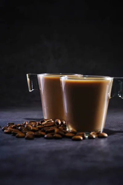 Dos tazas de café con leche y granos de café dispersos —  Fotos de Stock