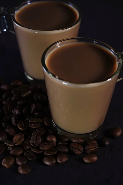 Dos tazas de café con leche y granos de café dispersos —  Fotos de Stock