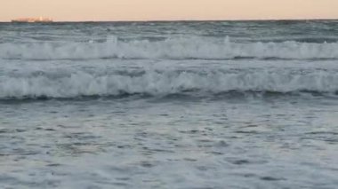 Gün batımında gelen küçük bir deniz dalgası