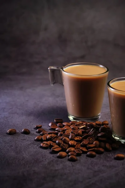 Dos tazas de café con leche y granos de café dispersos —  Fotos de Stock