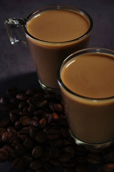 Dos tazas de café con leche y granos de café dispersos —  Fotos de Stock