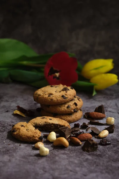 Biscoitos de chocolate e tulipas em um fundo cinza — Fotografia de Stock