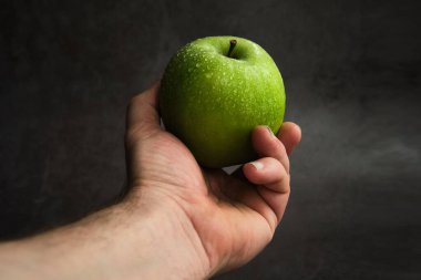 yeşil elma bir erkeğin elinde