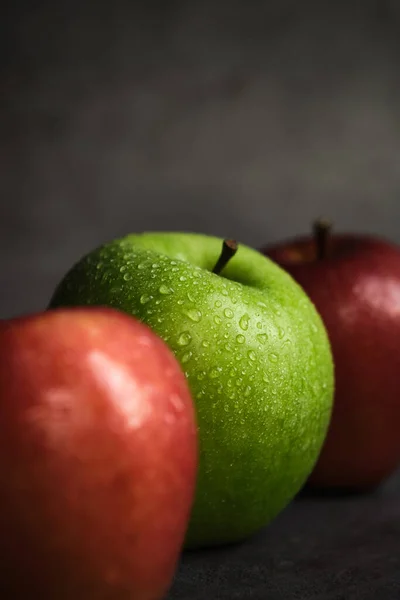 Trois pommes sur un fond sombre — Photo