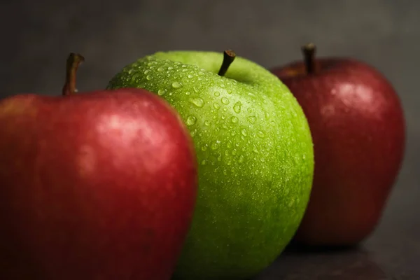 Trois pommes sur un fond sombre — Photo