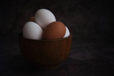 Beyaz ve kahverengi tavuk yumurtaları kasede.