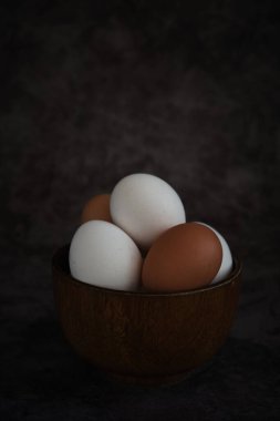 Beyaz ve kahverengi tavuk yumurtaları kasede.