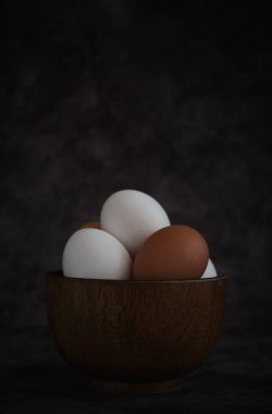 Beyaz ve kahverengi tavuk yumurtaları kasede.